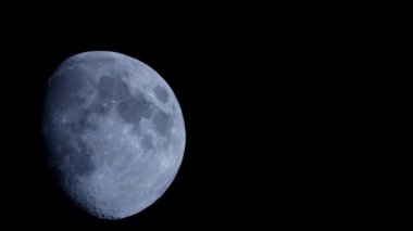 Büyük ve detaylı bir balmumu ayı, gece gökyüzünün karanlık atmosferinde zarifçe süzülür. Ay yüzeyindeki birçok krater ve gölgeyi ortaya çıkarır.