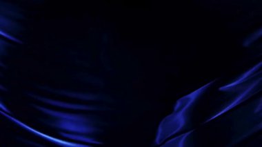 Zarif mavi ipek kumaşın soyut sinematik çekimi yumuşak ışık altındaki sıvı dalgalar gibi dalgalanıyor ve zarifçe hareket ediyor gizemli desenler ve gölgeler yaratıyor.