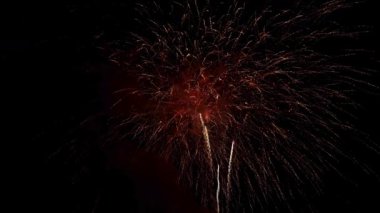 Şiddetli kırmızı ve altın sarısı havai fişekler büyük bir kutlama sırasında yoğun dumanla gökyüzünde patlıyor.