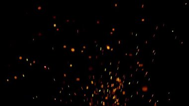 Yanan turuncu közler ve kıvılcımlar karanlık bir gecede bir yangından ya da şenlik ateşinden siyah bir arka plana doğru uçuyor.
