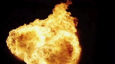 Dinamik ateş topu patlaması, kıvrımlı sarı ve turuncu alevlerin siyah bir zemine doğru patlaması yoğun bir görsel etki yaratıyor.