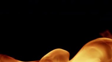 Doğal turuncu alevler dans ediyor ve koyu siyah bir zemin üzerinde yanıp sönerken aynı zamanda ışık ile sıcak bir ısı efekti sağlıyor.