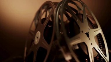 Klasik sinema ve film yapımcılığının altın çağını temsil eden karanlık bir stüdyo ortamında yavaşça dönen klasik metal film koleksiyonu.