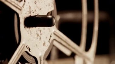 Eski sinematik projeksiyon teçhizatının detaylı hareketlerini ve mekanik kısımlarını gösteren dönen film makarasının merkezini kapat