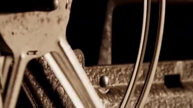 Eski bir sinema projektörünün paslı metal film makaralarını kapatın. Sıcak bir ışığın gölgelerini yakalarken hızla dönüyor.