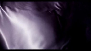 Güzel mor ipekten kumaşlar dalgalanır ve dalgalanır yumuşak röfleler ve derin gölgeler lüks bir estetik ve organik sıvı hareketi yaratır.