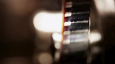 Klasik bir projektör mekanizmasının içinden geçen 35 mm 'lik klasik film şeridi yumuşak, sıcak ışıklandırmalı karanlık bir odada.