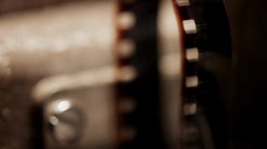 Klasik film projektörü roketleri 35 milimetrelik film makarasını Bokeh 'le birlikte karanlık bir odada kaydırıyor.
