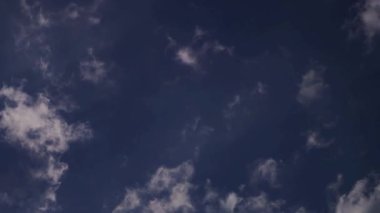 Açık, güneşli bir günde, hafif rüzgar ve esintiyle mavi bir gökyüzüne saçılmış, seyrek, küçük beyaz bulutlar.