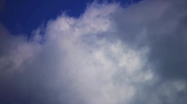 Hafif ışıkla mavi gökyüzünde hareket eden dramatik kara bulutlar doğa arkaplan görselleri için karamsar ve sinematik bir atmosfer yaratıyor.