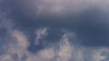 Çerçeveyi dolduran ve gökyüzünde yavaşça hareket eden ağır kara fırtına bulutları dışarıda karamsar ve tehlikeli bir atmosfer yaratıyor.