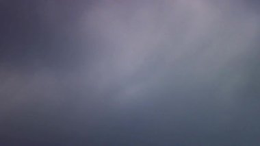 Yoğun gri bulutlar, bulutlu ve kasvetli bir günde, yumuşak ve dağınık doğal ışıklandırmayla gökyüzünde yavaşça ilerliyorlar.