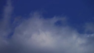 Hızlı hareket eden beyaz bulutlar canlı mavi bir gökyüzünde sürükleniyor ve her türlü doğal görüntü projesi için güzel bir arka plan oluşturuyor.