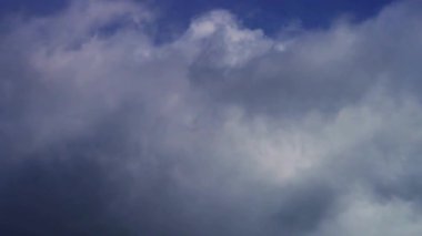 Bulutlu bir öğleden sonra atmosferde hızla ilerleyen beyaz lekelerle gökyüzünde toplanan dramatik kara fırtına bulutları.