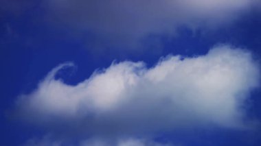 Sessiz ve sakin bir sonbahar gününde parlak mavi bir gökyüzü boyunca ince ince beyaz bir bulut oluşumu yatay olarak uzanıyor.