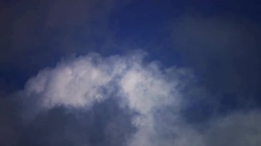 Büyük dramatik gri ve beyaz bulutlar şiddetli bir yaz fırtınasından önce koyu mavi bir gökyüzünde hareket eder.