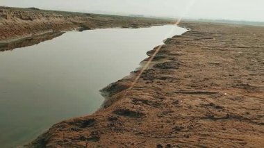 Dar akıntı aşınmış kumlu nehir yatağını kesiyor.