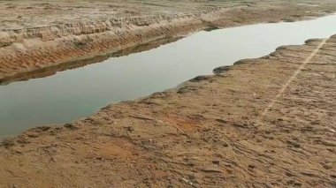 Dar akıntı aşınmış kumlu nehir yatağını kesiyor.