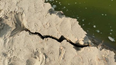Şiddetli nehir kıyısı erozyonu Yansıtıcı Su Yüzeyi 'nin yanında çatlak bir uçurum.