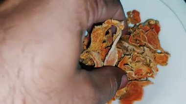 Beyaz kasedeki organik kuru zerdeçal dilimlerinin yakın görüntüsü