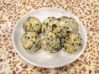 Close up of Jumeokbap, a typical Korean food rice ball, made of rice, carrot, chicken meat, and seaweed. Korean fist rice ball is famous dish in South Korea and the world. Food photography.