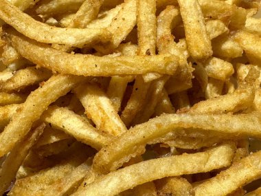 Patates kızartması ya da patates kızartması dokusunu kapat. Kızarmış Shoestring kızartmaları batı yemeklerinde yaygındır, karbonhidrat ve yağ açısından zengindir. Yemek fotoğrafçılığı dokusu.