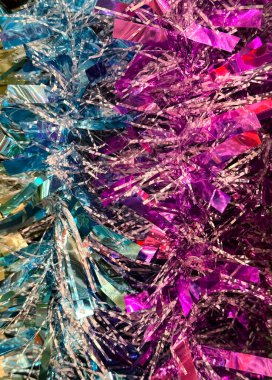 Noel süslerinin arkaplan dokusu rengarenk renkli çelenkler. Mavi, pembe, kırmızı, altın ve mor renkler. Teneke kutular Noel ağacı ya da odaları süslemek için kullanılan parlak kağıtlardır. Mutlu Noeller.