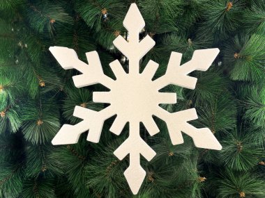 Beyaz kar tanelerinin, yeşil Noel ağacı arkaplanlı kesim şekillerini kapatın. Noel dekorasyonu, kış ve mevsim kutlamaları. Kusursuz arkaplan dokusu. Mutlu Noeller.