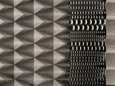 Gri maddeye oyulmuş, rastgele üçgen geometrik şekil ve şablona 3D oyma yakın çekim. Duvar dekorasyonu ve iç dekorasyon için uygun. Kusursuz arkaplan dokusu