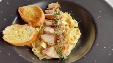 Spagetti soslu tavuk ve sarımsaklı ekmeğin servis edilmeye hazır olduğu görüntüler. Turntable yiyecek video konsepti. Lezzetli makarna