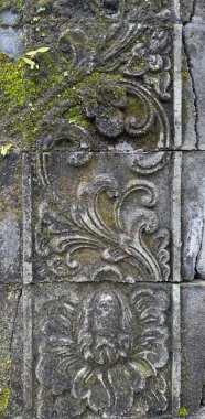 Karanlık taşın üzerine oyulmuş kabartma oyma kabartmaları, rastgele süslemeler ve taş bir duvara kazınmış çiçek girdapları. Geleneksel antik tapınak modeli. Kusursuz arkaplan dokusu.