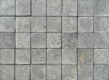 Kare gri kaldırım taşları rastgele gölgeli ve pürüzlü. Dış bahçe döşemesi için uygun. Kusursuz arkaplan dokusu.