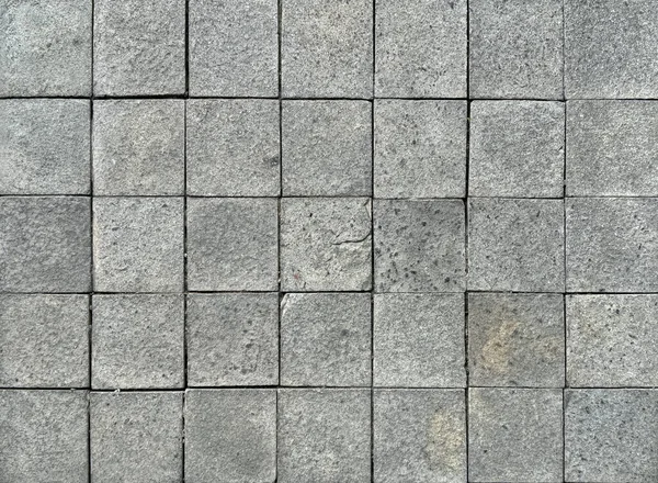 Kare gri kaldırım taşları rastgele gölgeli ve pürüzlü. Dış bahçe döşemesi için uygun. Kusursuz arkaplan dokusu.