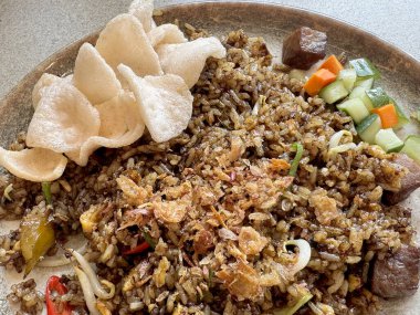 Geleneksel Endonezya usulü kızarmış pirinç, kızarmış biftek, haşlanmış yumurta, kızarmış soğan, soğan ve karides krakeri. Endonezya Güneydoğu Asya yerel lezzetleri. Lezzetli ve lezzetli. Yemek fotoğrafçılığı.