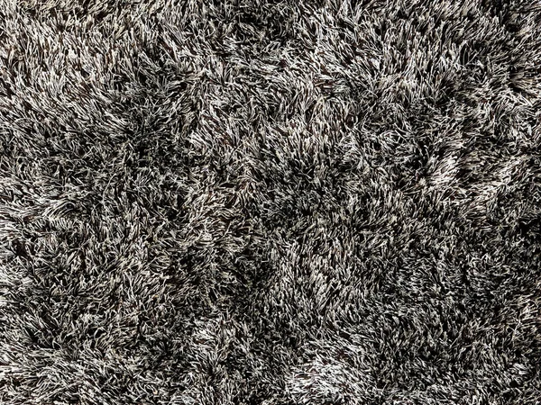 Halı döşemesini siyah lüle renginde kapat. Tüylü, kürklü, kahverengi renkli kumaş. Tüylü kürklü, kusursuz, minimalist halı dokusu. Oturma odası için uygun.