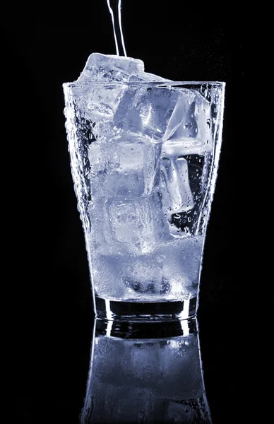 Pooring dryck i ett glas med is — Stockfoto