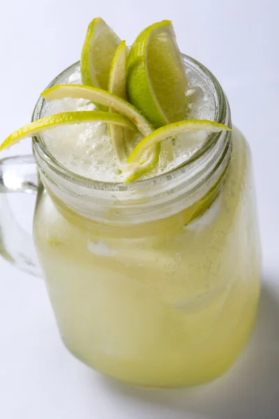 Bebida fresca fria da limonada com limão em um fundo branco, perto — Fotografia de Stock