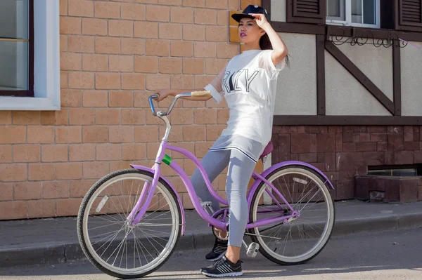 Jeune belle femme sur un vélo — Photo