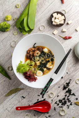 Beyaz tabakta et, erişte ve sebze li sebze çorbası