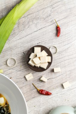 Kare tofu sebze ile siyah bir plaka üzerinde