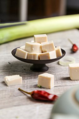 Kare tofu sebze ile siyah bir plaka üzerinde