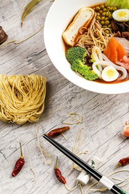 Deniz ürünleri, erişte ve beyaz bir tabakta sebze çorbası