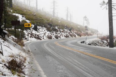 Kar Tahoe Gölü dağ yolunu kapladı. Yol bir kış fırtınası sırasında buzlu koşullarda ele geçirilir..