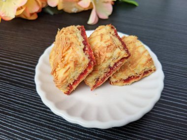 Beyaz bir tabakta çilekli peynir. Bayram kutlamaları için popüler kurabiyeler (Hari Raya). Hari Raya için ünlü Malezya tatlıları