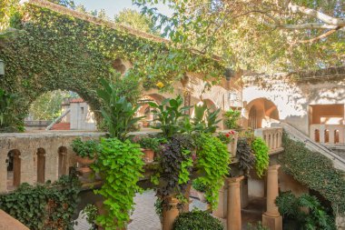 Meksika tarzı, Talaquepaque Sanat Köyü, Sedona, Arizona, ABD 'de iki katlı sarmaşıklı, ağaçlı ve yürüyüş yollu bir avlu..