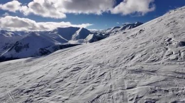 Gürcistan 'ın Gudauri kentinin nefes kesici güzelliğini keşfedin. Karla kaplı zirveler parlak mavi gökyüzünün altında kayak maceralarını davet ediyor..