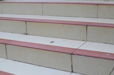 Pembe kenarlı kentsel beton merdivenlerin detaylı yakın çekimi yapısal tasarım ve dış mekanda dokulu yüzey gösteriyor..