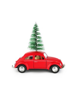 Kırmızı bir oyuncak araba, çatısına güvenli bir şekilde yerleştirilmiş küçük yeşil bir Noel ağacını kaprisli bir tatil ruhunu yansıtıyor. Bu neşeli sahne neşeli bir dokunuş sergiliyor.