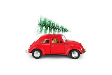 Kırmızı bir oyuncak araba, çatısına güvenli bir şekilde yerleştirilmiş küçük yeşil bir Noel ağacını kaprisli bir tatil ruhunu yansıtıyor. Bu neşeli sahne neşeli bir dokunuş sergiliyor.