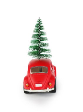 Çatısı yeşil bir Noel ağacıyla kaplı parlak kırmızı bir klasik araba sürüyor. Bu festival sahnesi bayram sezonunun ruhunu yansıtıyor. Kutlama ve neşe için mükemmel..